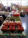 Photo of vendor table displaying miscellaneous vegetables for sale.