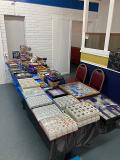 Photo of vendor table displaying miscellaneous rare coins and currency for sale.