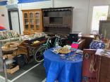 Photo of vendor table displaying miscellaneous household items and furniture for sale.